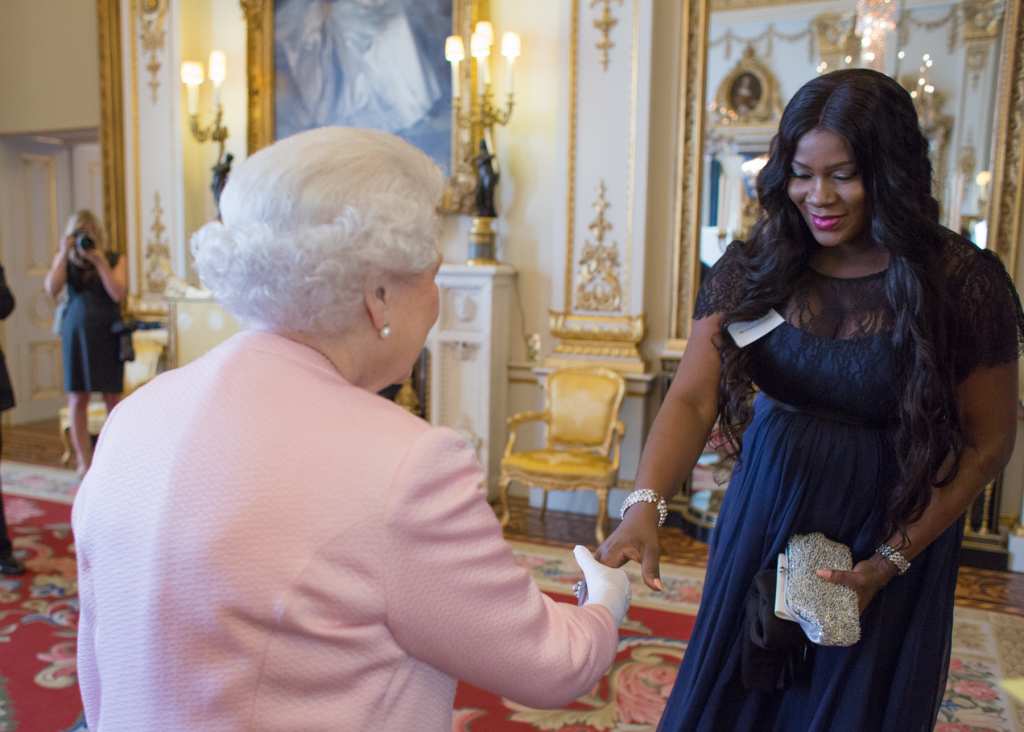 STEPHANIE LINUS AND LINUS IDAHOSA WITH THE QUEEN OF ENGLAND