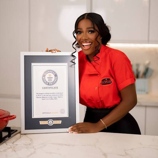Hilda Baci proudly holding her Guinness World Record certificate after completing her 93-hour cooking marathon in Lagos, Nigeria.- OLORISUPERGAL MEDIA